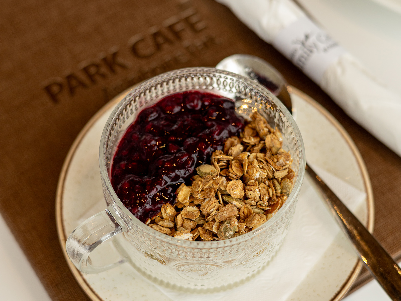 a yogurt parfait sits on a park cafe menu